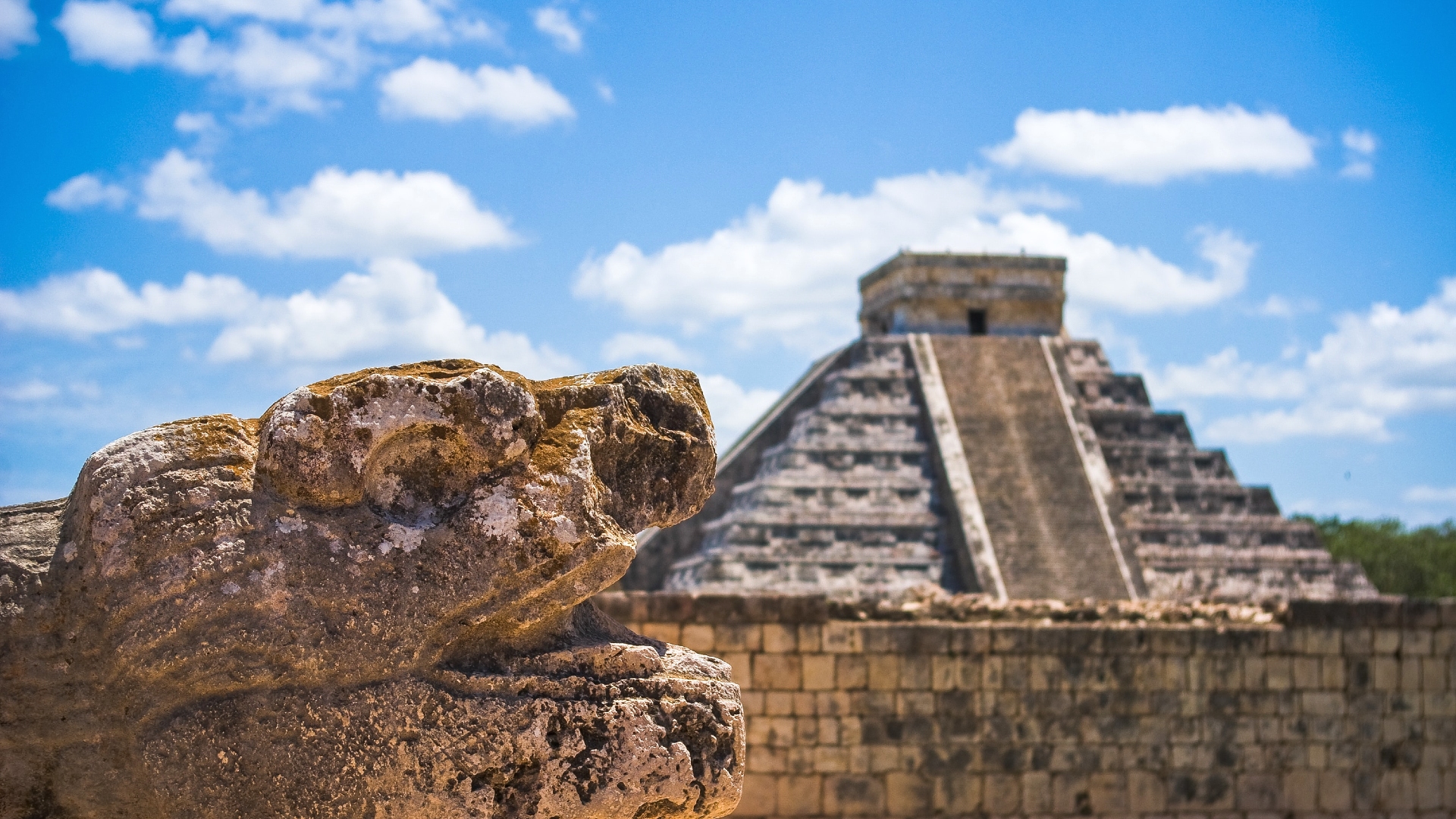 Detalle de una escultura de origen maya con la pirámide de Kukulkán en Chichén Itzá, México Detalle de una escultura de origen maya con la pirámide de Kukulkán en Chichén Itzá, México