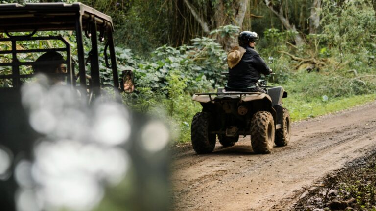 Hombre en quad pasea por la selva seguido de un vehículo todoterreno