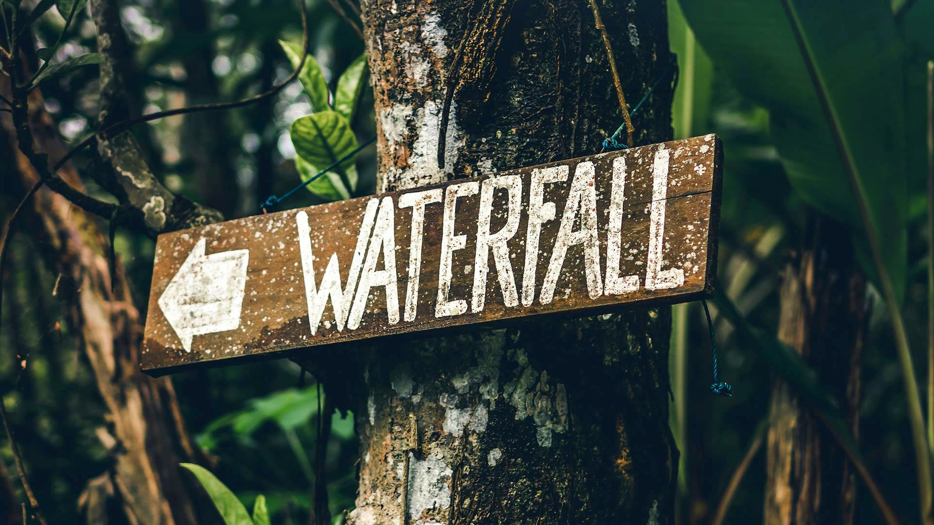 Cartel en Bali indicando la dirección hacia una cascada Cartel en Bali indicando la dirección hacia una cascada