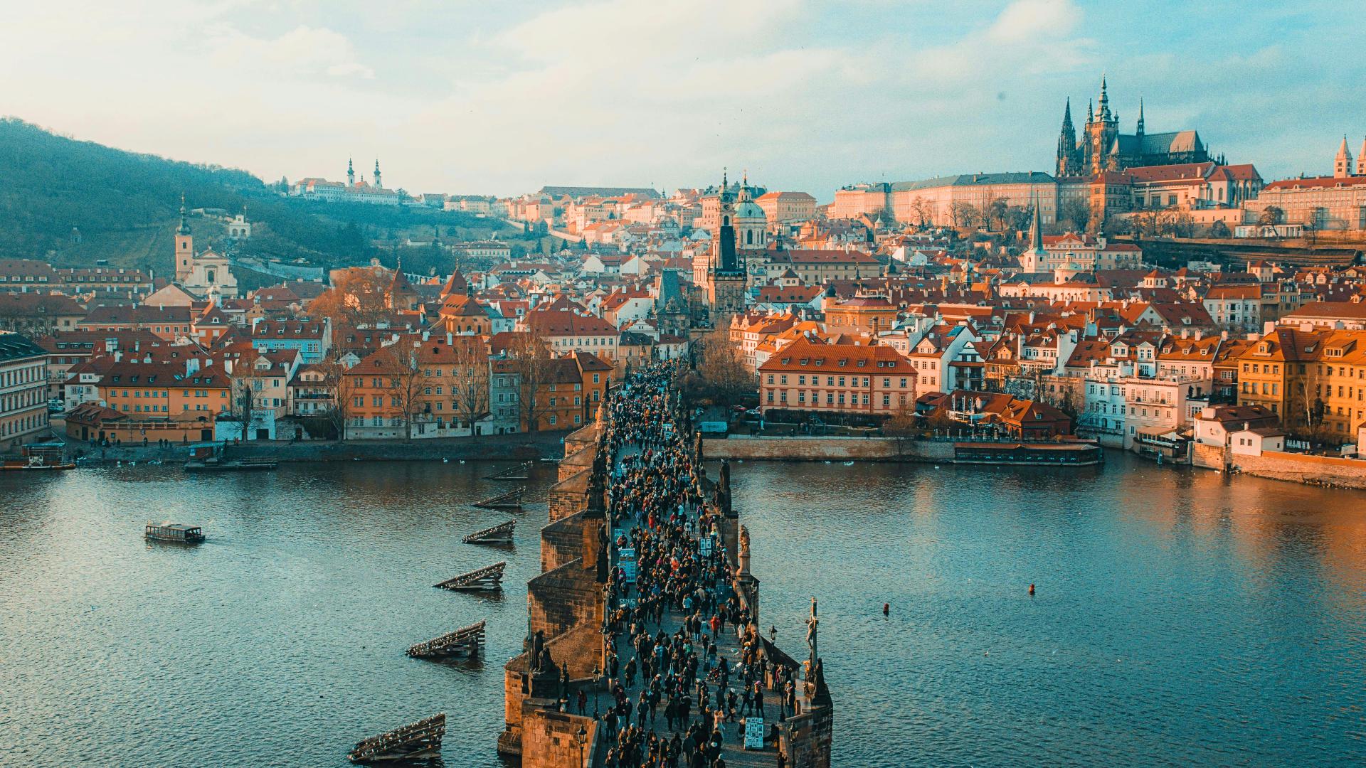 Puente Carlos abarrotado de turistas con el Castillo de Praga al fondo