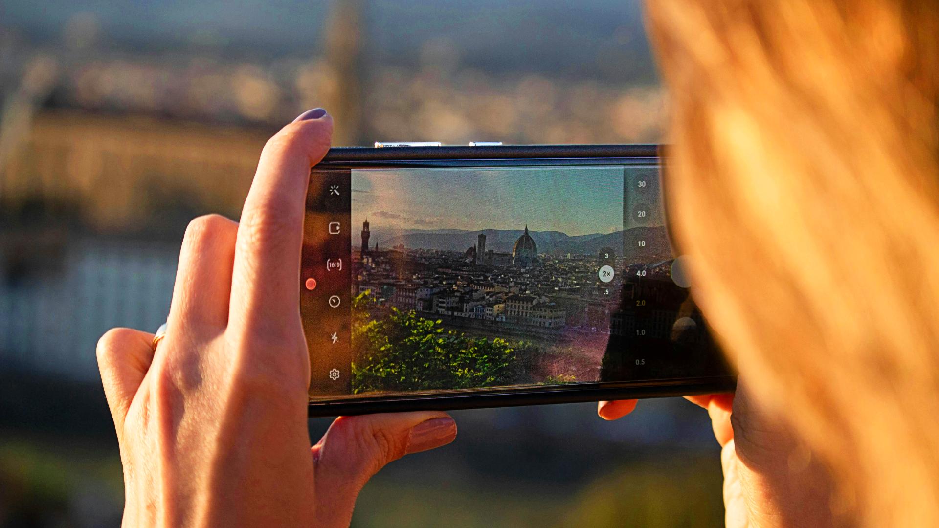 Turista fotografiando las vistas desde el mirador de la Piazzale Michelangelo