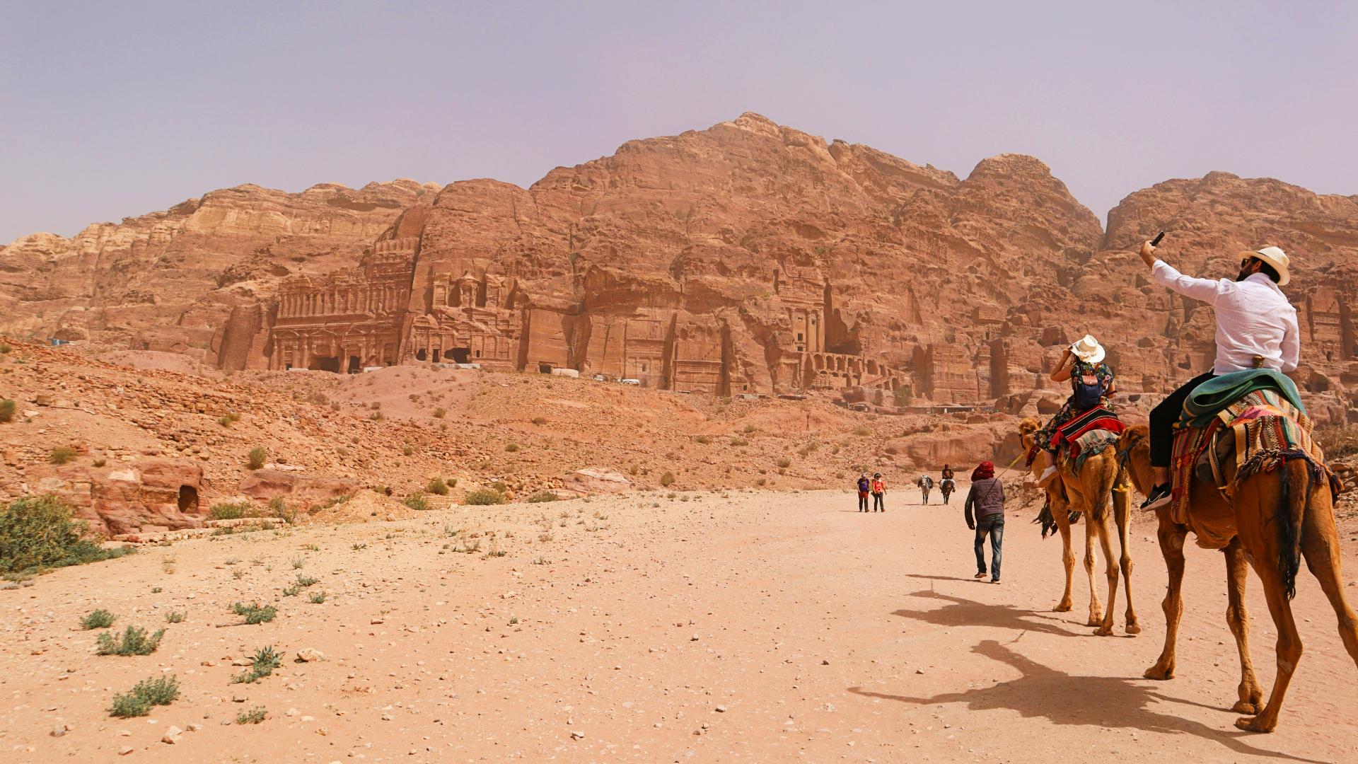 Turistas accediendo a las ruinas de Petra en camello