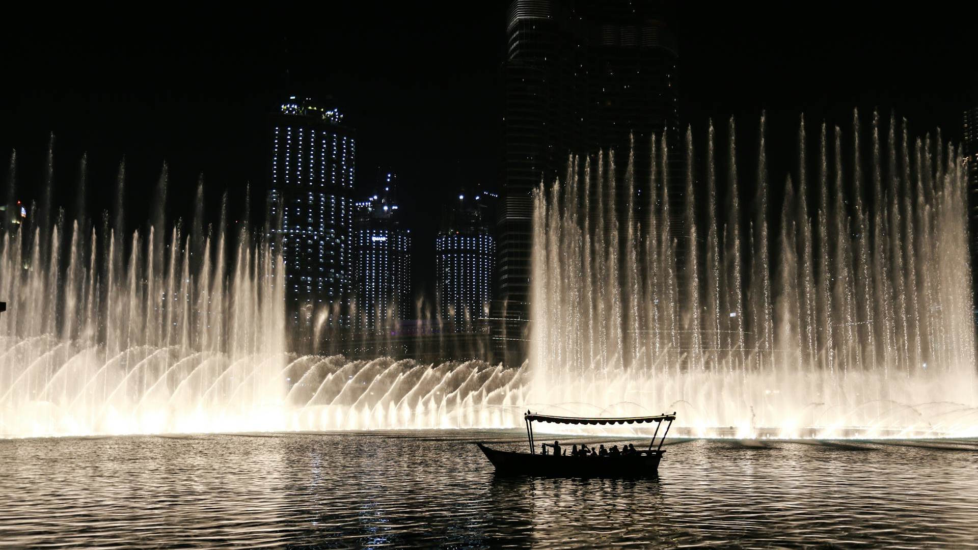 Abra, embarcación tradicional, navegando por el lago mientras se muestra el espectáculo de luces Abra, embarcación tradicional, navegando por el lago mientras se muestra el espectáculo de luces
